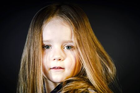Attractive little girl close-up portrait, isolated on blackの写真素材