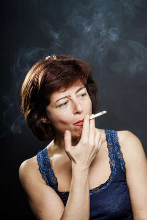 Young woman smoking cigarette, healthcare concept, isolatedの写真素材