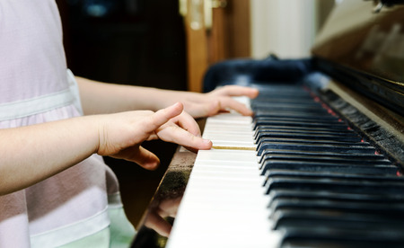 Girl's hands and piano keyboard close-up view, education conceptの写真素材