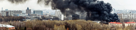 Column of black smoke rising above fireplace in Moscow, Russia