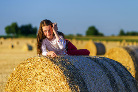 Teenage girl with long hair posing in summer field, countryside, Alsace, France
