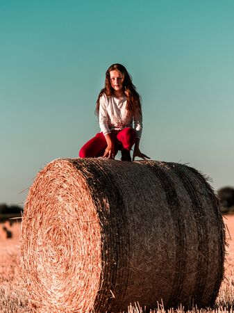 Teenage girl with long hair posing in summer field, countryside, Alsace, Franceの写真素材