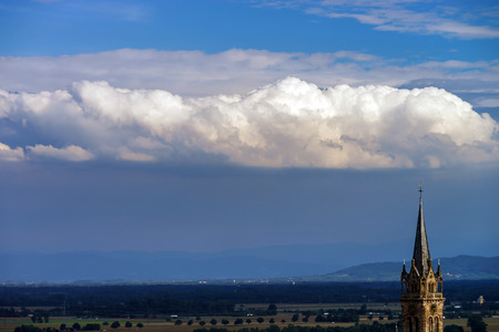 Beautiful big cloud over the belltower of old church, Franceのeditorial素材