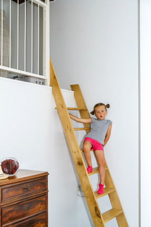 Cute little girl posing indoor on staircaseの写真素材