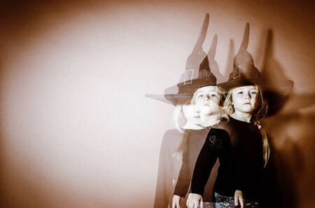 Halloween mystic photo with mixed light. Cute little girl multi-portraitの写真素材