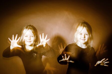 Halloween mystic photo with mixed light. Cute little girl multi-portraitの写真素材