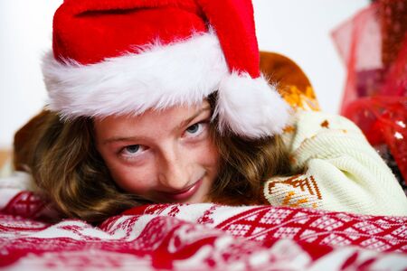 Teenage girl in red santa hat christmas portrait, isolated on whiteの写真素材