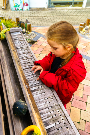 Cute little musician playing old broken piano in the public parkの写真素材
