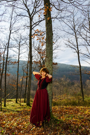 Woman in red renaissance dress portrait, autumnal forest, Franceの写真素材