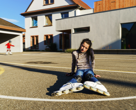 Teenage girl faaled down while running rollers, sunny day