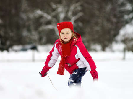 Little girl playing with snow while snowflurry, France