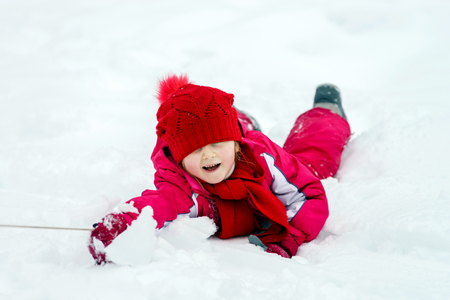 Children have a roll in the snow, winter dayの写真素材