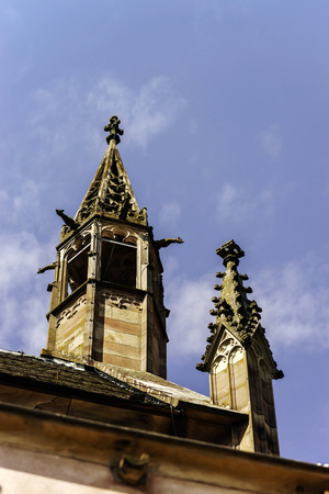 Gargoyle on a gothic cathedral, detail of a tower on blue sky background, Saint Florent church, Niederhaslach, Franceの写真素材