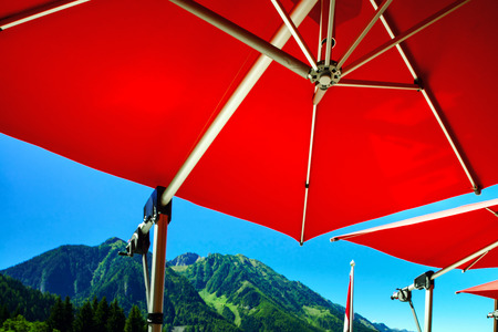Big red sun umbrella over the street cafe, Austria, mountain resortの写真素材