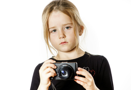 Cute little girl with compact digital camera, isolated on white backgroundの写真素材