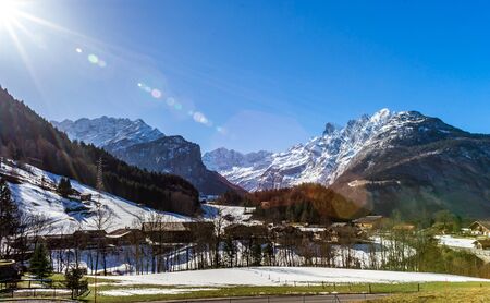 Alpine natural landscape with green fields, high rocks and white clouds, Switzerlandの写真素材