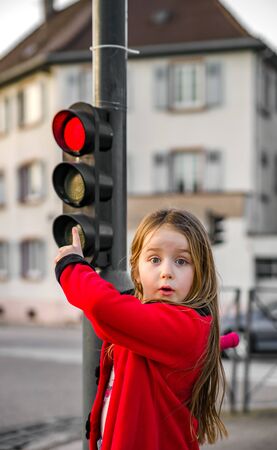 Cute little girl posing with small traffic lightの写真素材