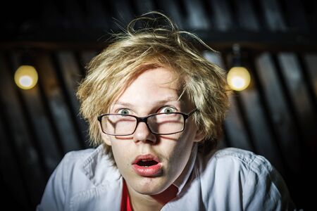 Funny teenage boy posing like a crazy professor or student, expressive person