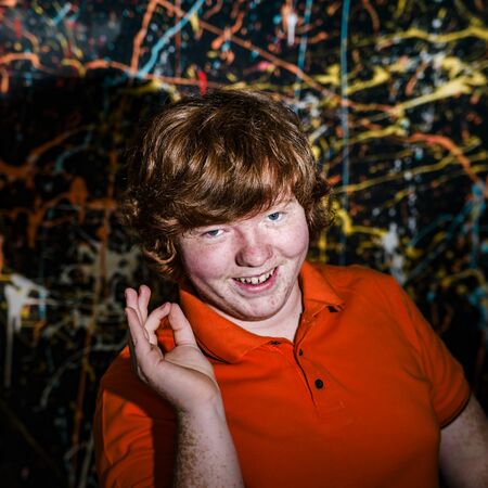 Funny red-haired boy showing ok sign, natural emotions