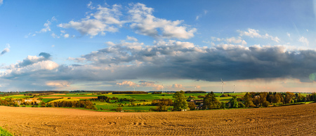 Colorful fields in belgian countryside panoramic view with windmill on horizon, Belgiumの写真素材