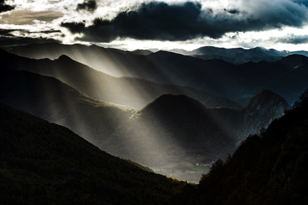 Sun rays lighting through the clouds in high Pyrenees, Franceの写真素材