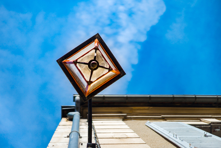 Old-styled street lamp on the wall of old house, on blue sky background, Auxerreのeditorial素材