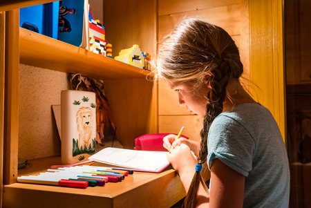 Cute little girl painting at home, comfort and harmony.の写真素材