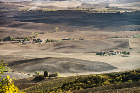 Autumn in Italy. Yellow plowed hills of Tuscany with interesting shadows and lines. Agricultural concept landscape.の写真素材