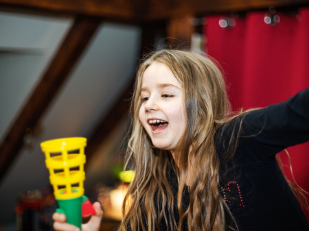 Cute little long haired girl playing games at home, hooligan type of childの写真素材