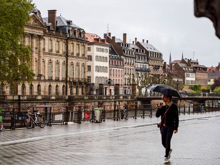 Editorial: 24th April 2019: Strasbourg, France. Rainy weather in old touristic center of the city. People walking with umbrellas.のeditorial素材