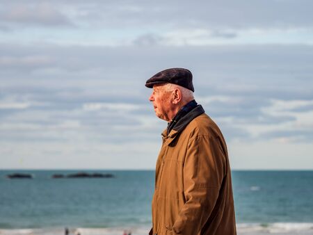 Editorial: 27th October 2019. Saint-Malo, France.  People stroll along the autumn promenade of Saint-Malo in Brittany. The sun comes out from behind the clouds and floods the beach with amazing beautiful light. Freedom and joy fill the heart.のeditorial素材