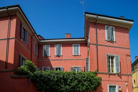 Bright and colorful Italian cityscape. Sunlit streets. Colorful houses. Warm and comfortable. Tourism and travel. The sea, palm trees and ancient shutters on all windows and balconies.の写真素材