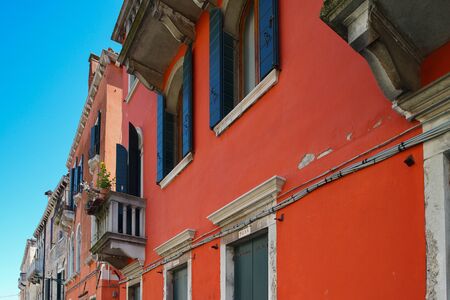 Tourist view of Venice. Channels with reflections. Street lights and colorful houses in the bright sun. Comfort and tranquility. Italy.の写真素材