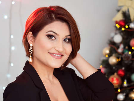 Christmas shooting. Beautiful model with New Year's gifts on the background of a Christmas tree.