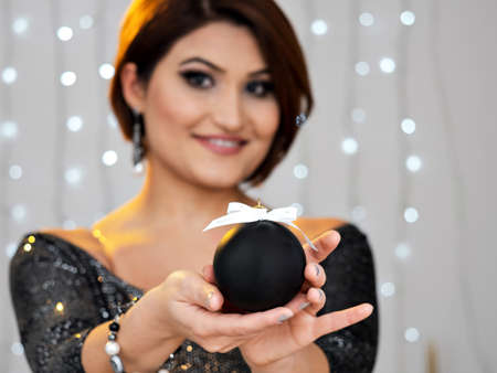 Christmas shooting. Beautiful model with New Year's gifts on the background of a Christmas tree.の写真素材