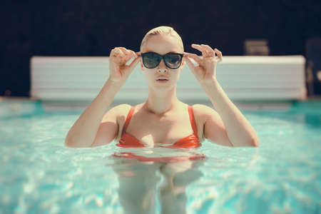 Young beautiful sexy girl enjoying swimming in the private pool and relaxing in the sun. Summertime.の写真素材