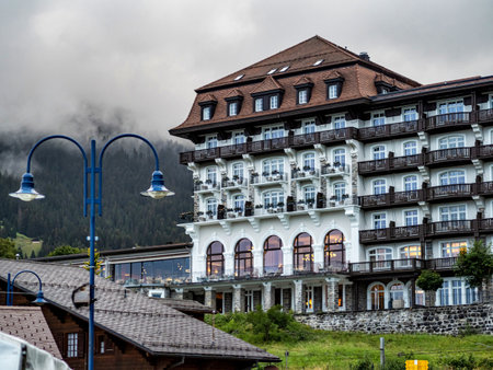 Alpine Swiss Village. Comfort and tranquility. A sunny summer day. Flowers on the windows. Wooden...