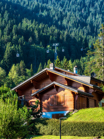 Alpine Swiss Village. Comfort and tranquility. A sunny summer day. Flowers on the windows. Wooden...
