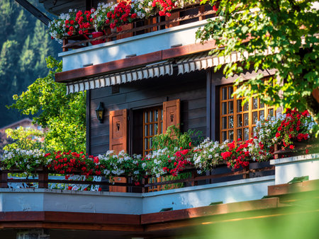 Alpine Swiss Village. Comfort and tranquility. A sunny summer day. Flowers on the windows. Wooden...