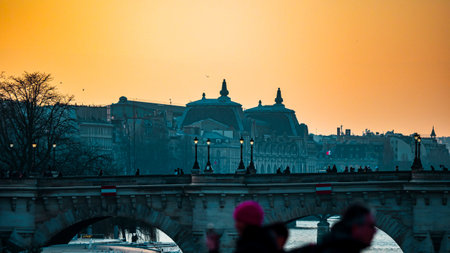 Sunset over the Seine in Paris. Silhouettes of bridges. Illuminated openwork lanterns on the bridges. Spring evening.の写真素材