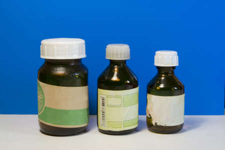 three bottles of medicine under standing on a blue backgroundの写真素材