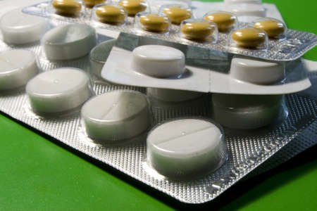 plates with pills on a green background, lying on each other