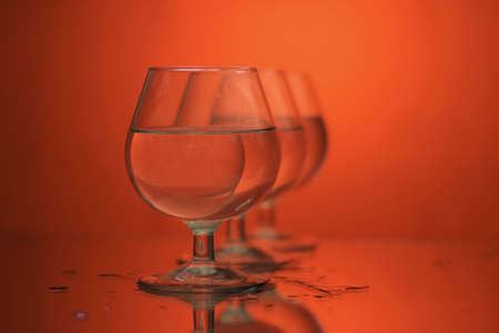 glass on a mirror and reflection orange backgroundの写真素材