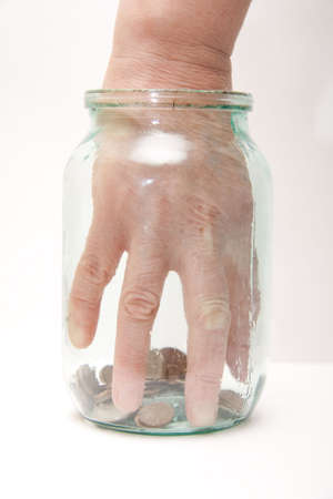 Close up of a female hand picking a money from glass jarの写真素材