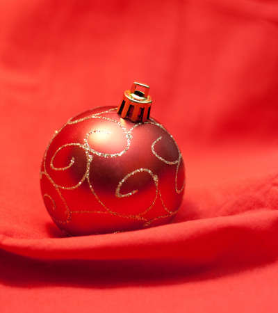 Red christmas ball with golden ornament on red backgroundの写真素材