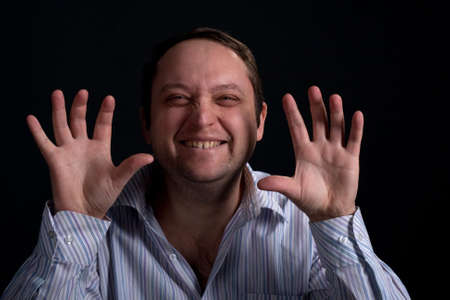 Young man with funny face in shirt and hands up