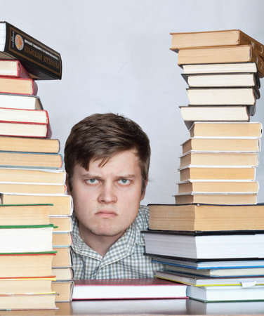 Young crazy discontent student between booksの写真素材