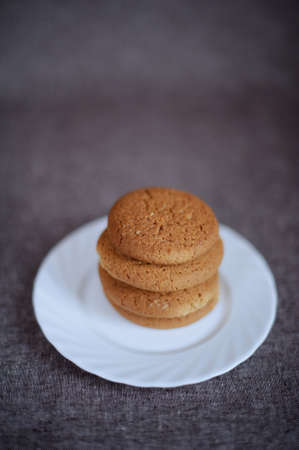 Oatmeal cookies on a white plate on brown backgroundの写真素材