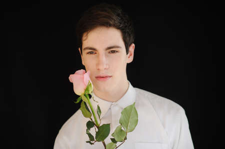 young man with a rose on the black backgroundの写真素材