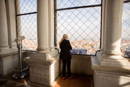 Venice, Italy - October 26, 2017: Woman on observation deck St. Mark's Campanile watching on Venice Panorama. Italy.のeditorial素材